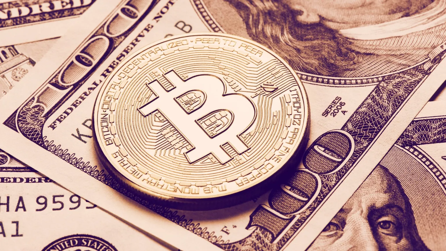 A Bitcoin resting on top of some dollars: Shutterstock