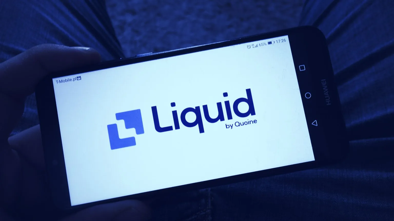 Man holding smartphone with Liquid cryptocurrency exchange logo. Image: Shutterstock