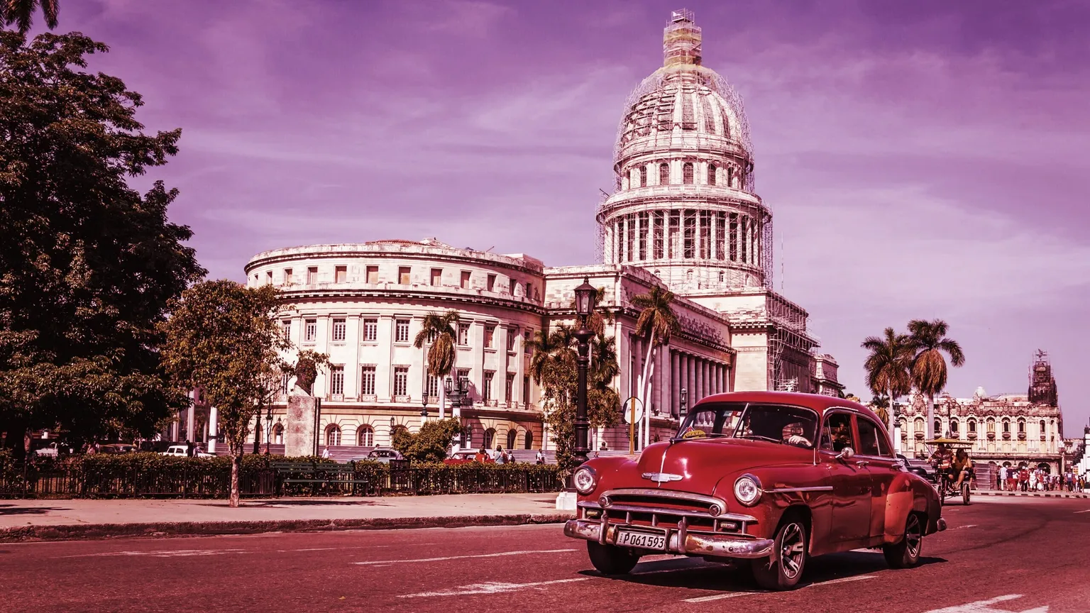 HABANA, CUBA - 2 DE DICIEMBRE DE 2013: Un viejo coche clásico americano de color granate circula frente al Capitolio. Antes de una nueva ley promulgada en octubre de 2011, los cubanos solo podían comerciar con coches que hubieran circulado antes de 1959.