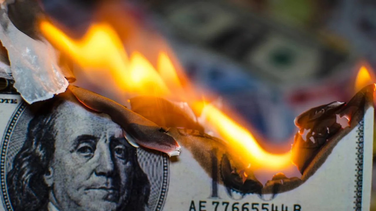 Un billete de cien dólares en moneda estadounidense se incendia.  Imagen: Shutterstock