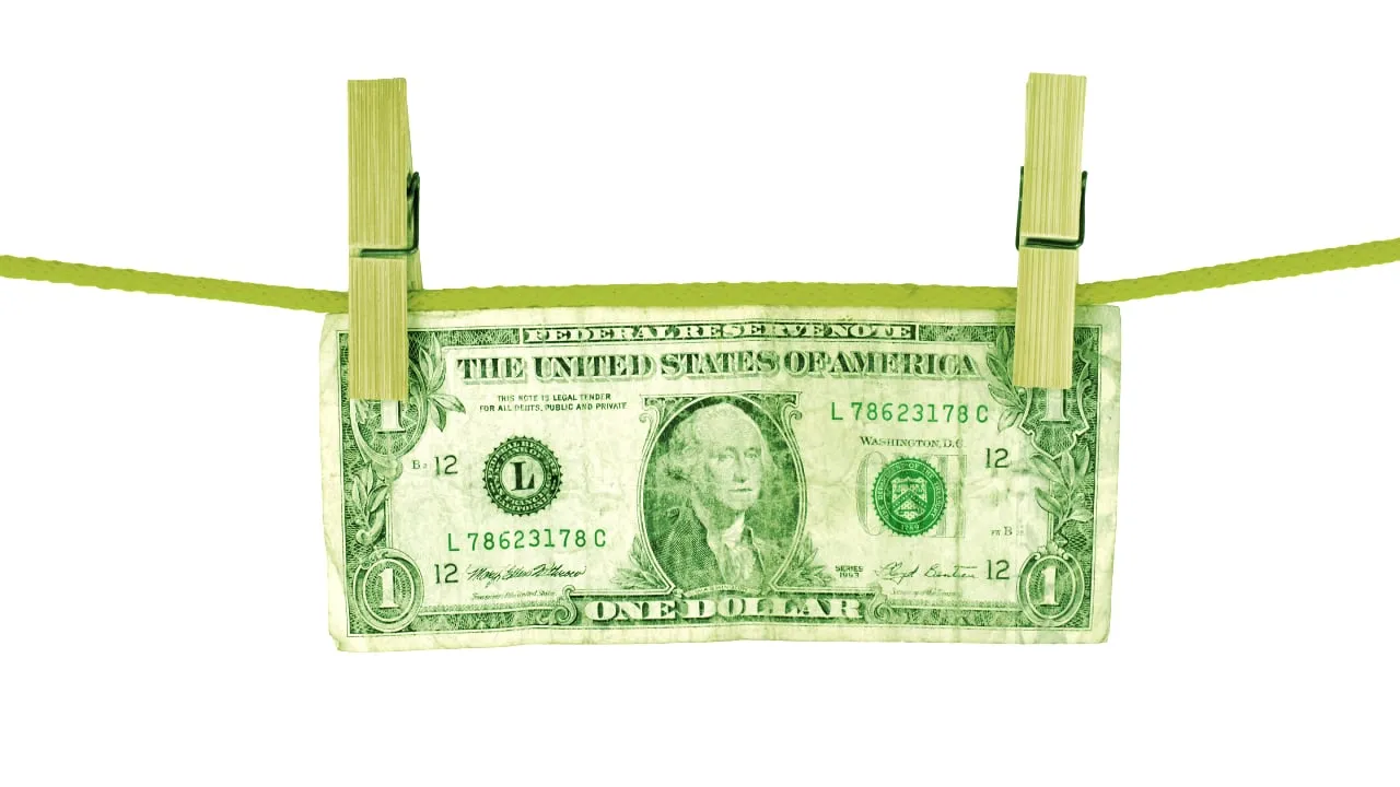 Billete de dólar colgando de las pinzas de la ropa. Imagen: Shutterstock