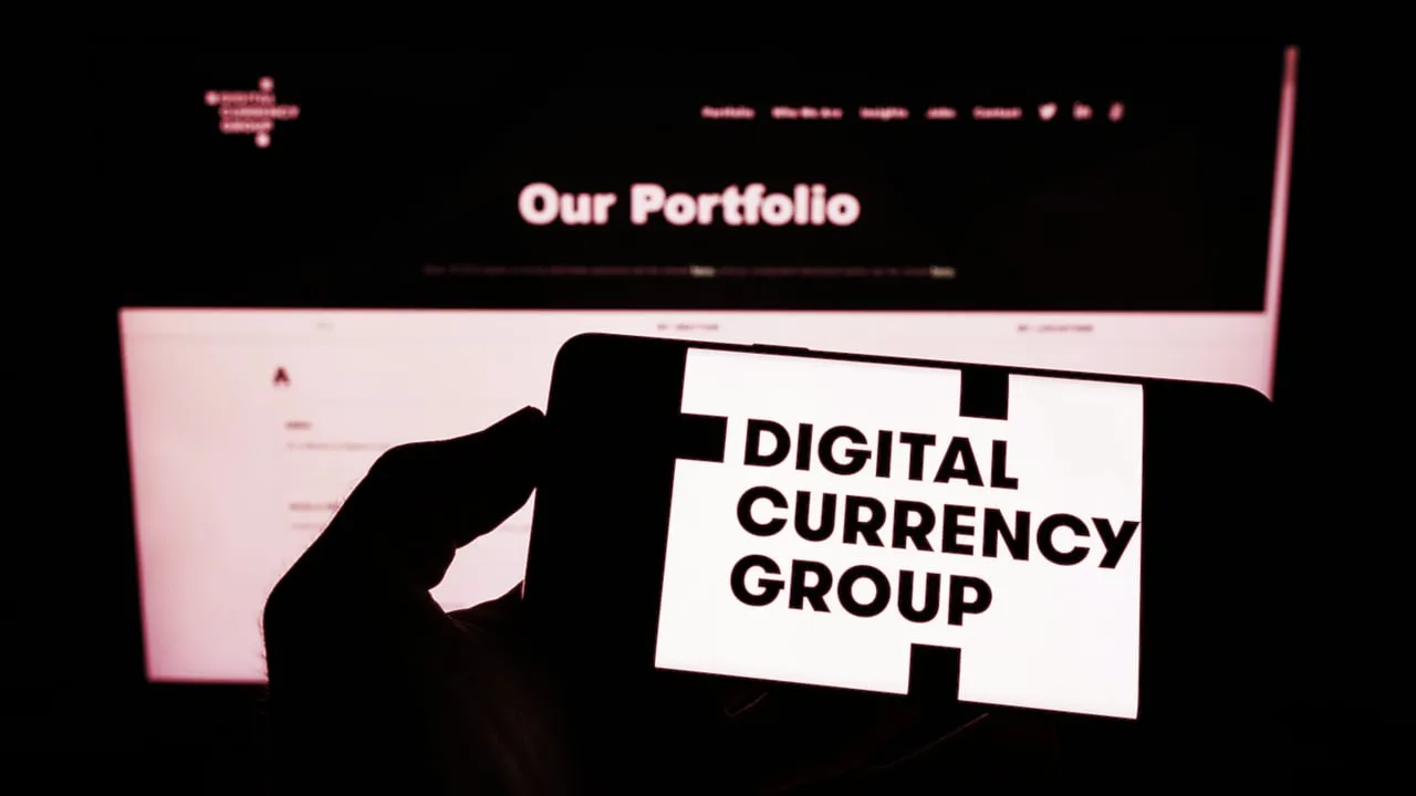 Stuttgart, Germany - 07-31-2022: Person holding cellphone with logo of US company Digital Currency Group Inc. (DCG) on screen in front of business web page. Focus on phone display. Unmodified photo.