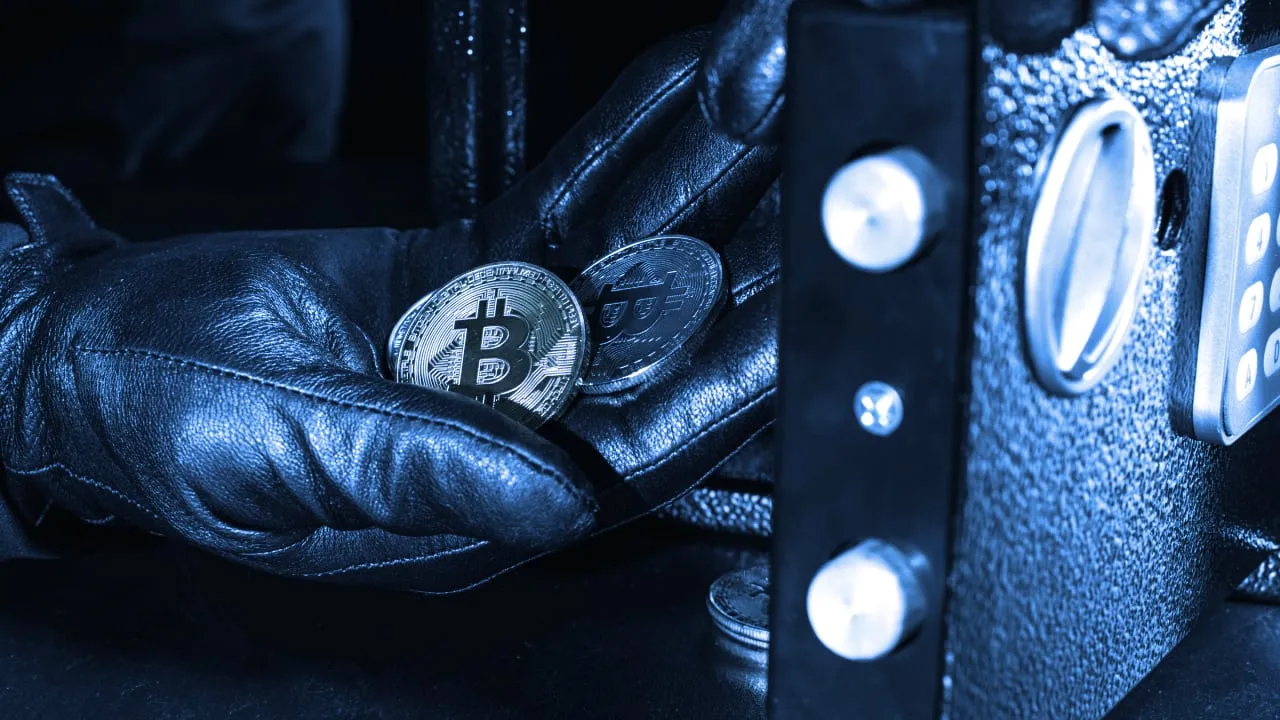 Thief hand stealing golden bitcoin from safe