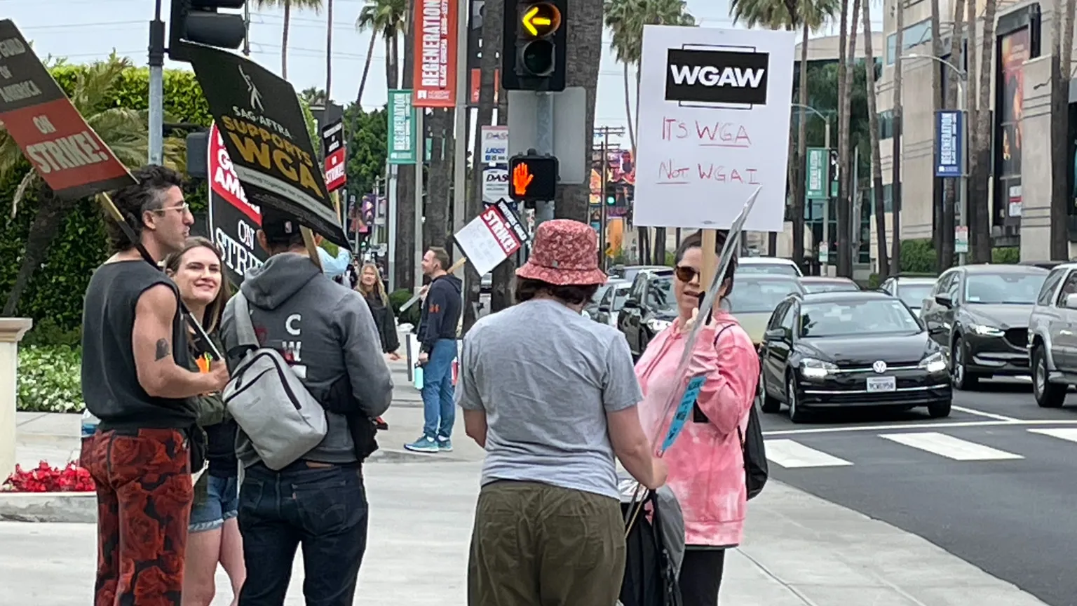 Un escritor sosteniendo un cartel que dice "Es WGA NO WGAI"