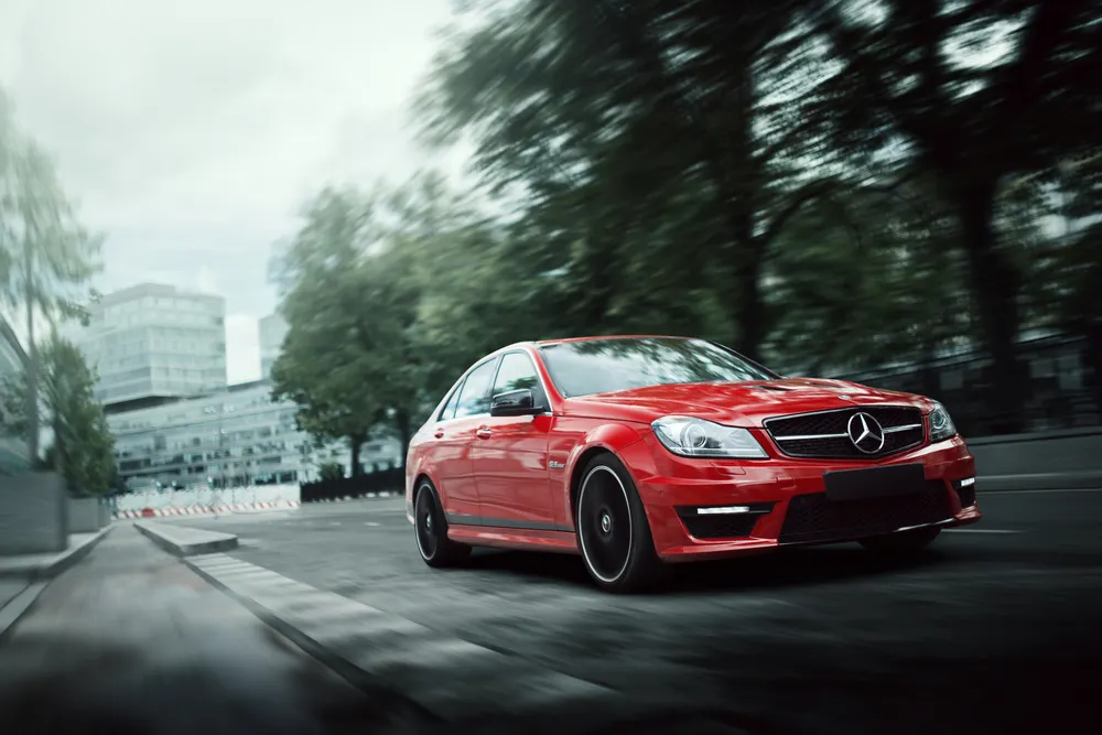 Red Mercedes driving on a street