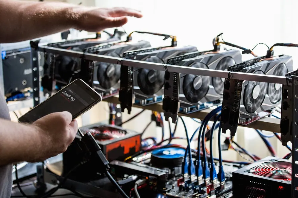 person checking a bitcoin mining rig