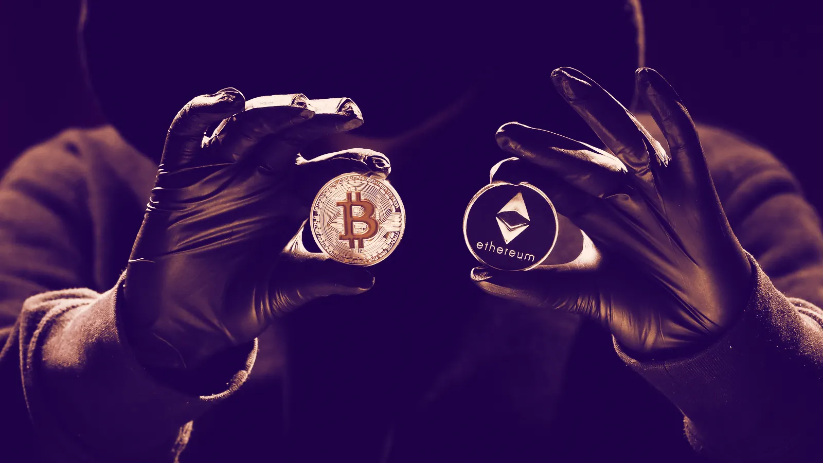 A hacker holding up Bitcoin and Ethereum coins. Image: Shutterstock