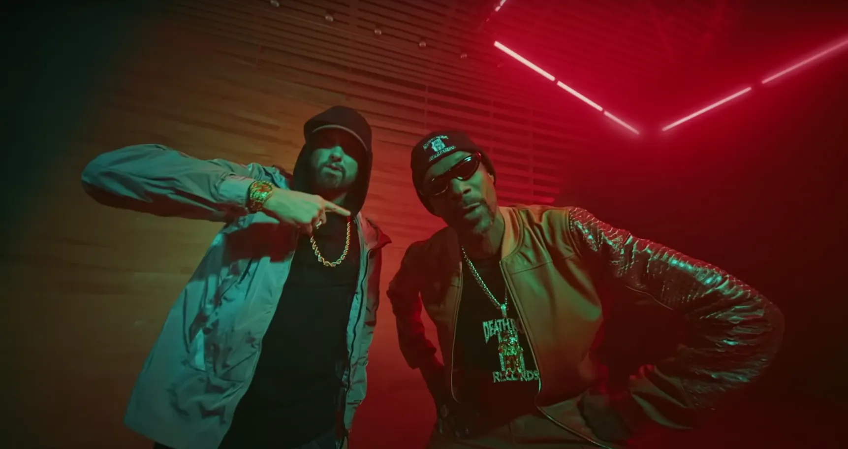 Snoop Dogg and Eminem rapping with green and red lighting in background.