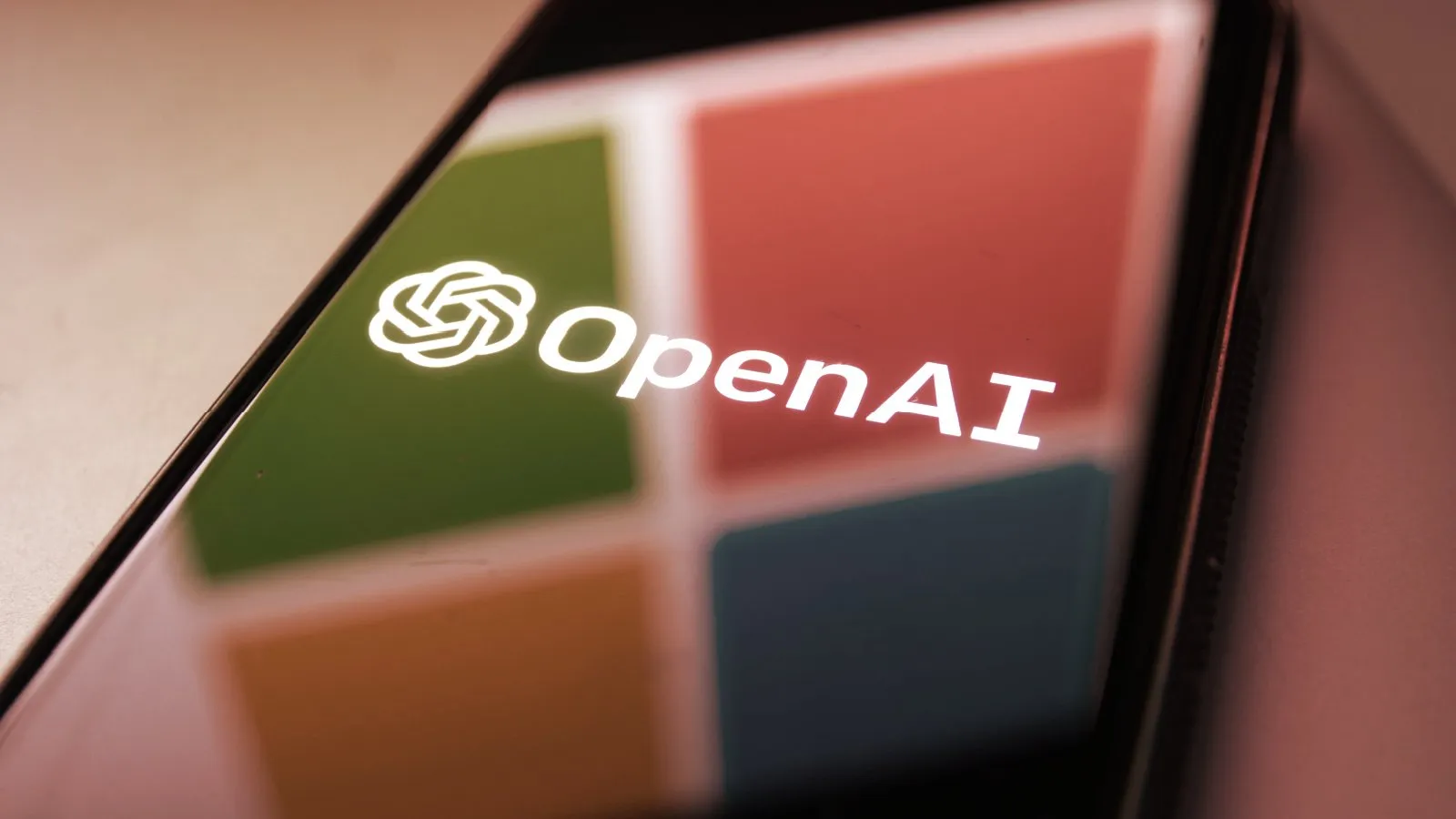 Microsoft logo reflection on smartphone with OpenAI logo. Source: Shutterstock