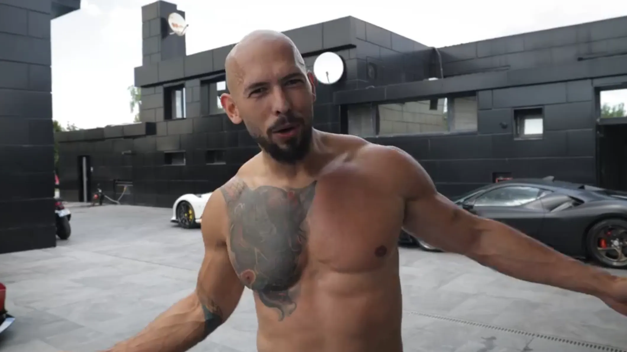 Andrew Tate stands topless at his house in Romania.