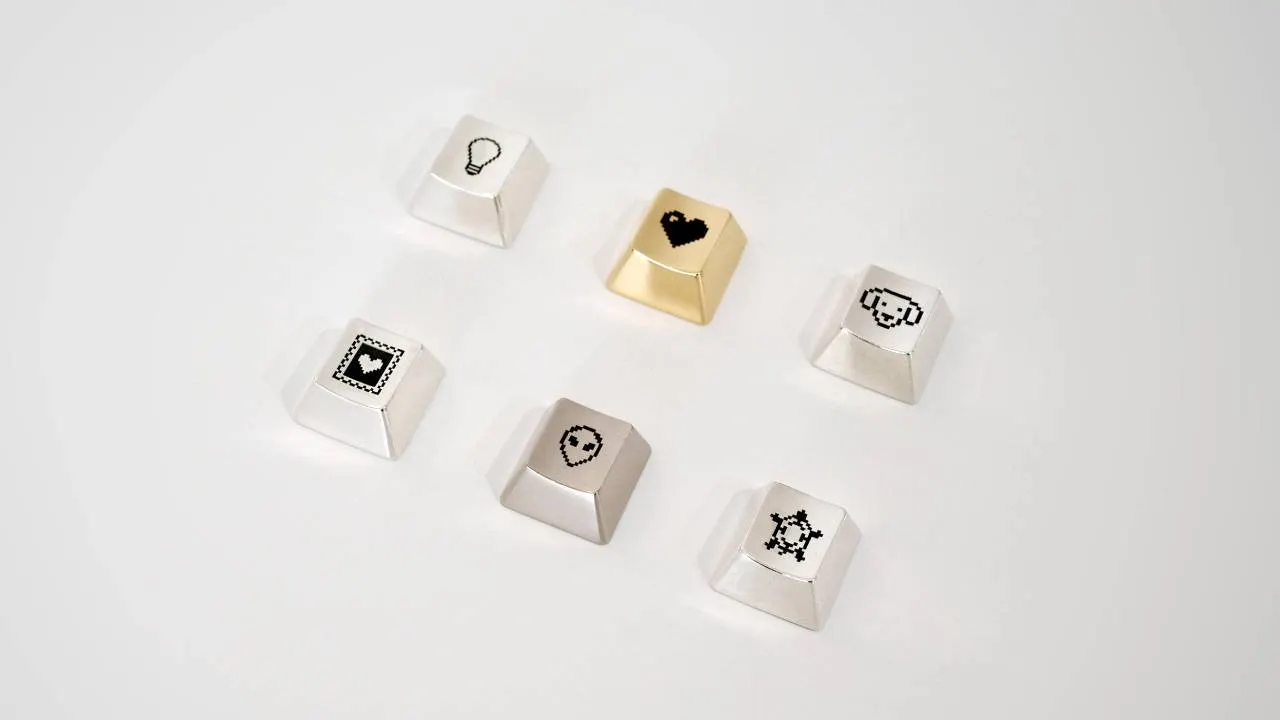 A set of metal keyboard keys with pixel art icons.